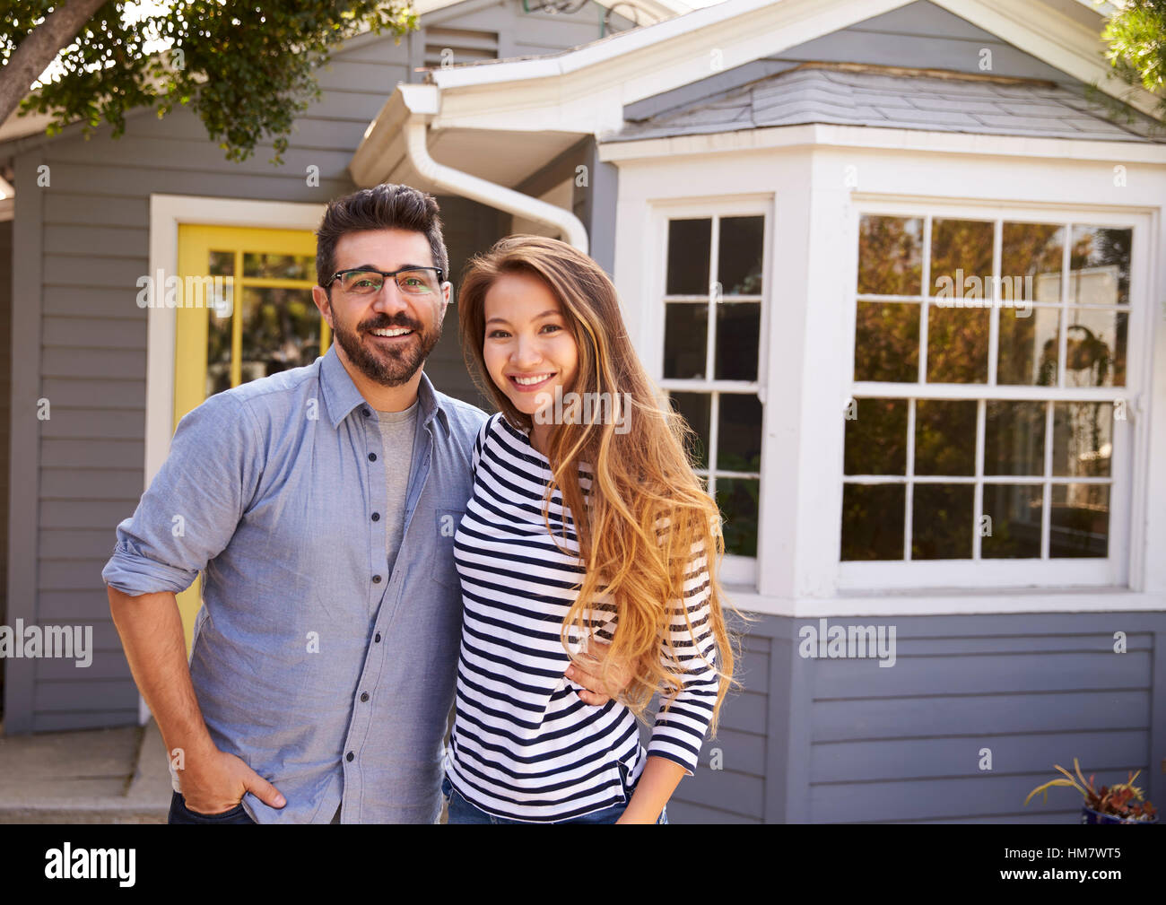 Portrait Of Excited Couple Standing Outside New Home Stock Photo - Alamy
