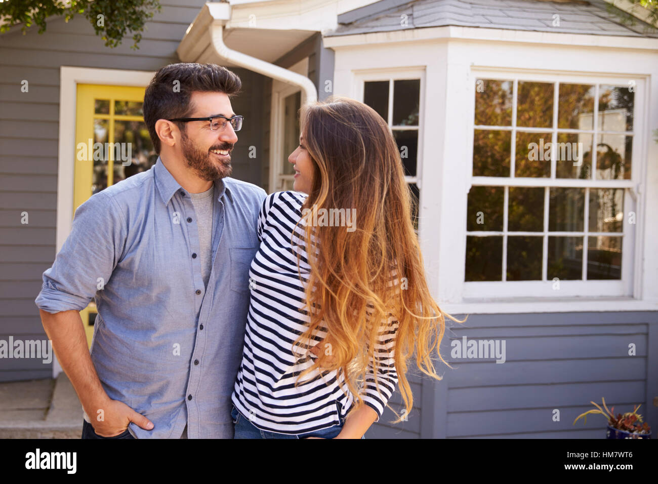 Portrait Of Excited Couple Standing Outside New Home Stock Photo - Alamy