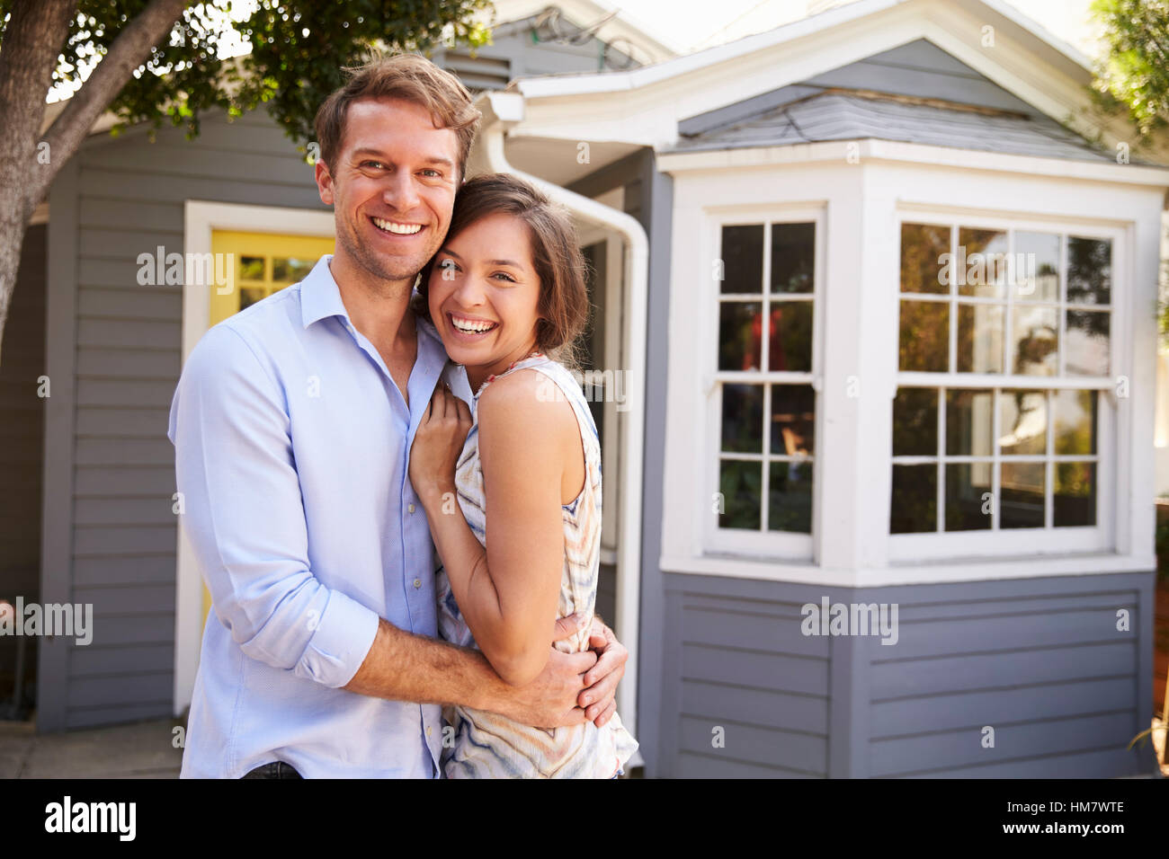 Portrait Of Excited Couple Standing Outside New Home Stock Photo - Alamy