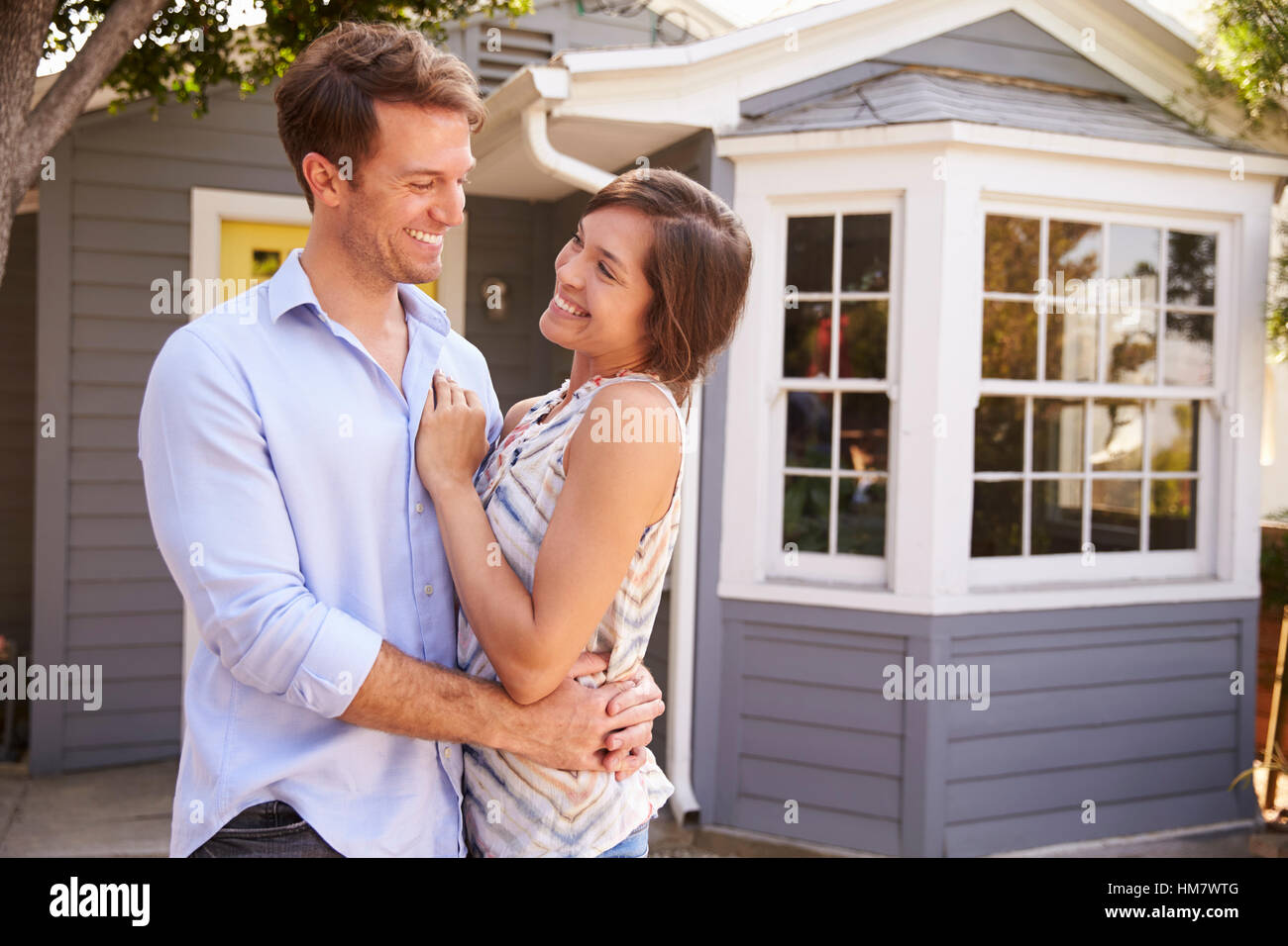 Portrait Of Excited Couple Standing Outside New Home Stock Photo - Alamy