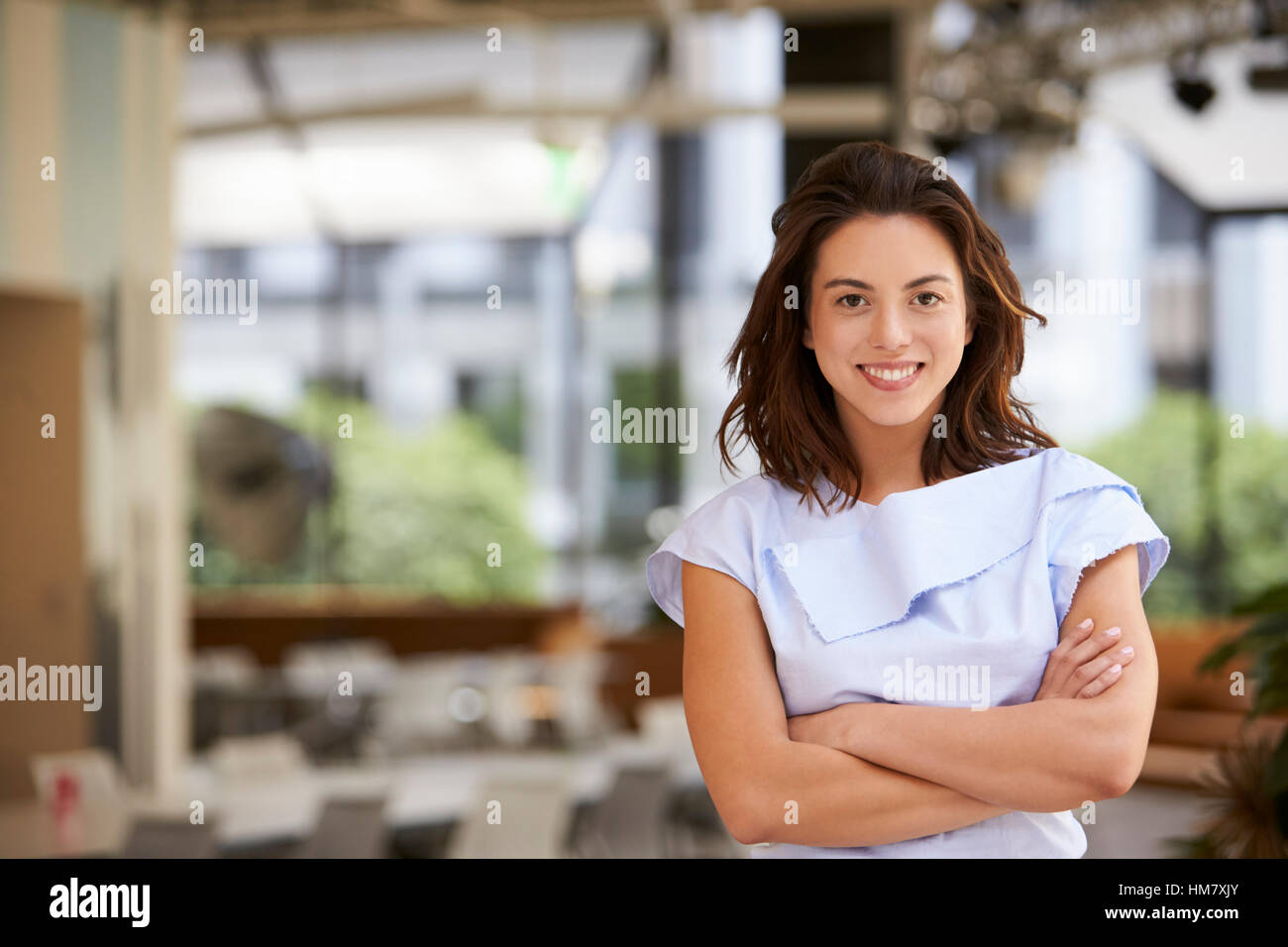 Portrait of young mixed race businesswoman with arms crossed Stock Photo