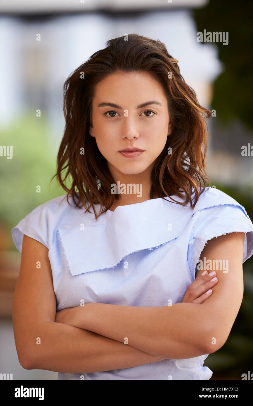 Young mixed race businesswoman with arms crossed, vertical Stock Photo