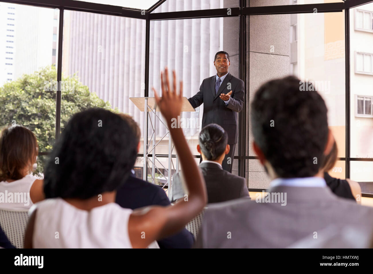Black businessman giving seminar takes audience questions Stock Photo