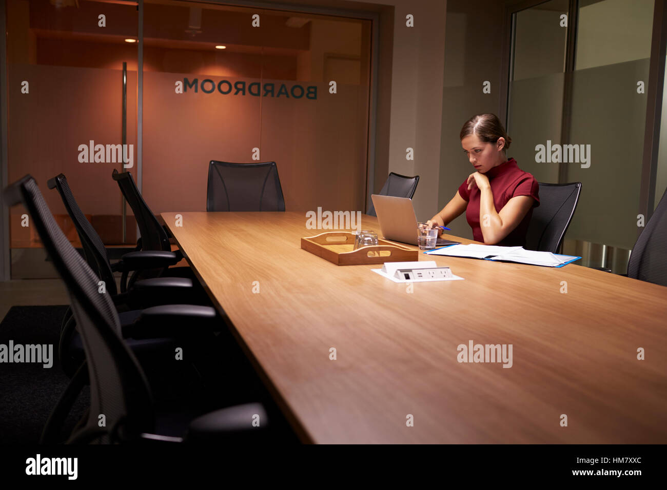 Young white businesswoman working alone late in an office Stock Photo