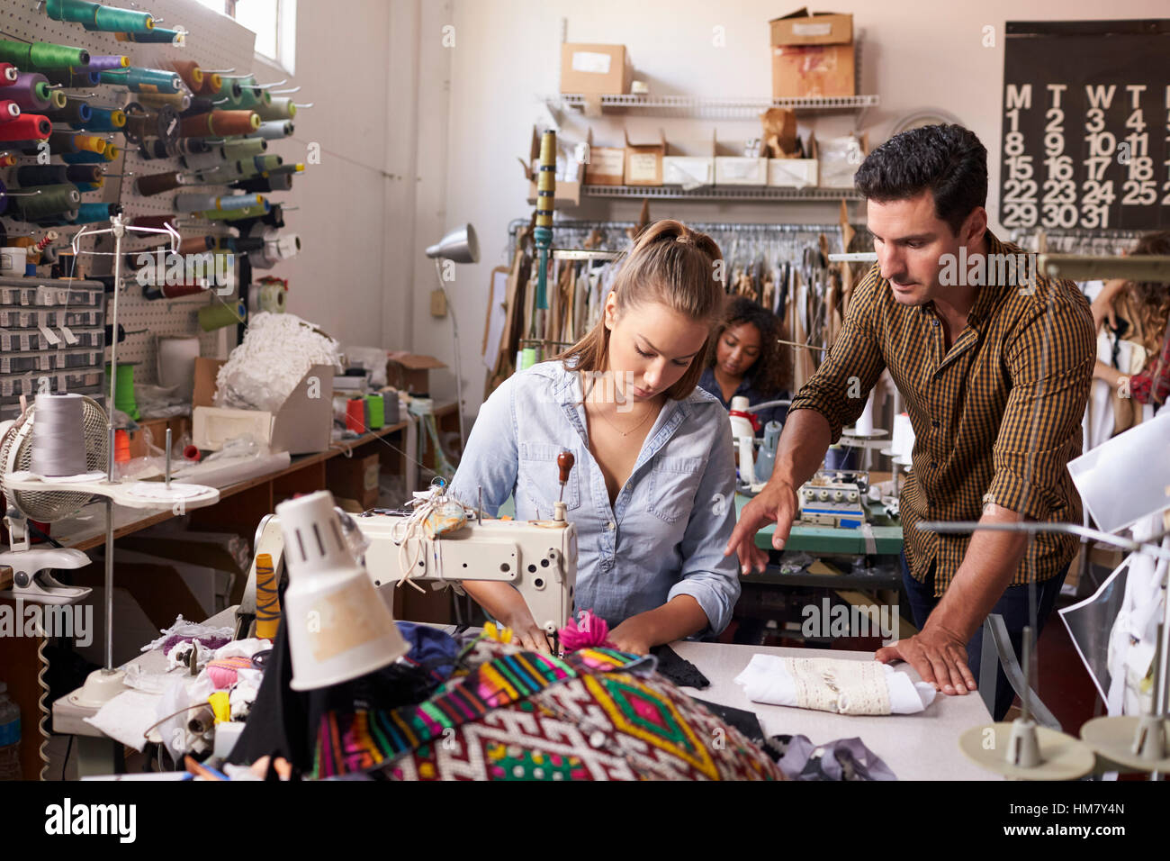 Manager instructing machinist at a clothing design studio Stock Photo