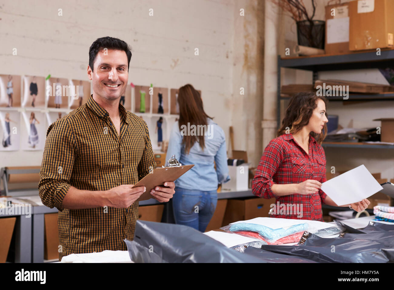 Hispanic man packs orders for distribution, smiles to camera Stock Photo