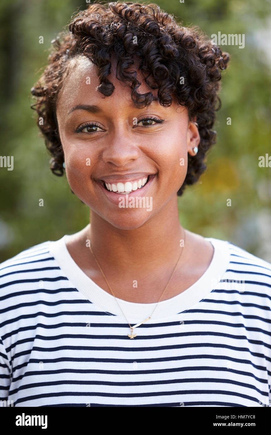 Portrait of smiling young mixed race woman, vertical Stock Photo