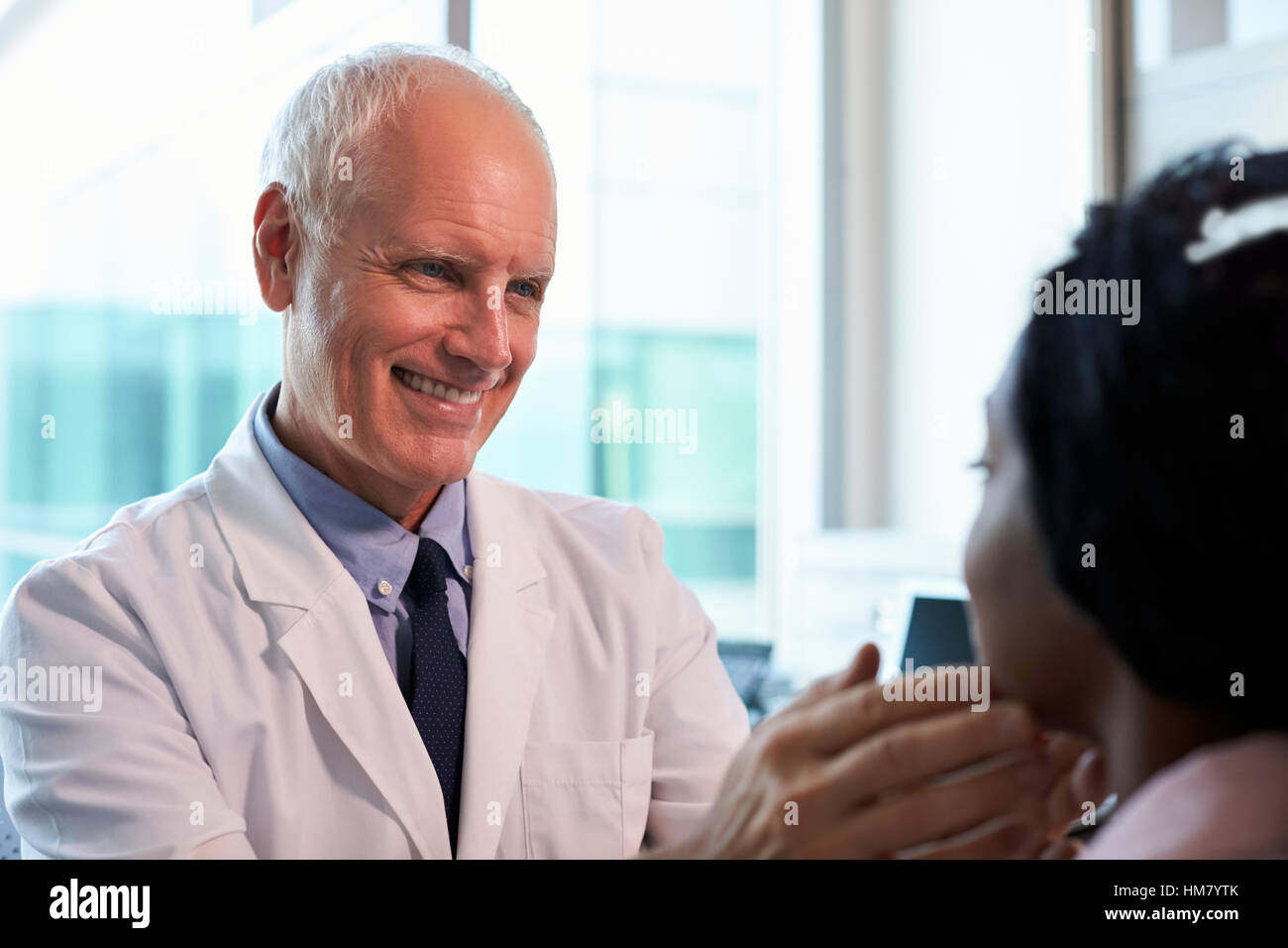 Doctor In White Coat Examining Female Patient In Office Stock Photo