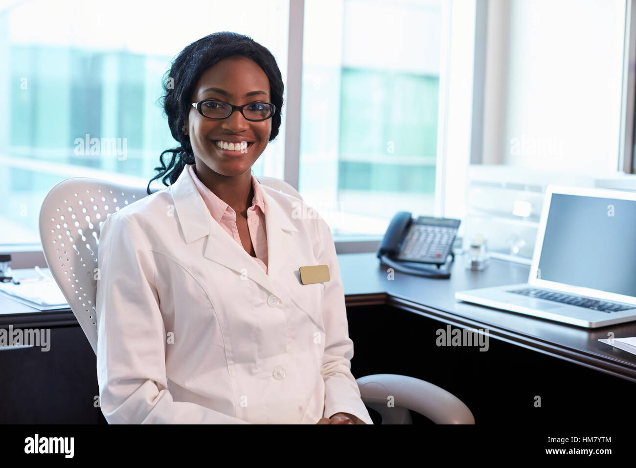 Portrait Of Female Doctor Wearing White Coat In Office Stock Photo