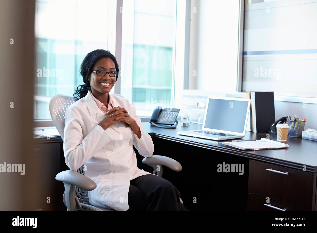 Portrait Of Female Doctor Wearing White Coat In Office Stock Photo