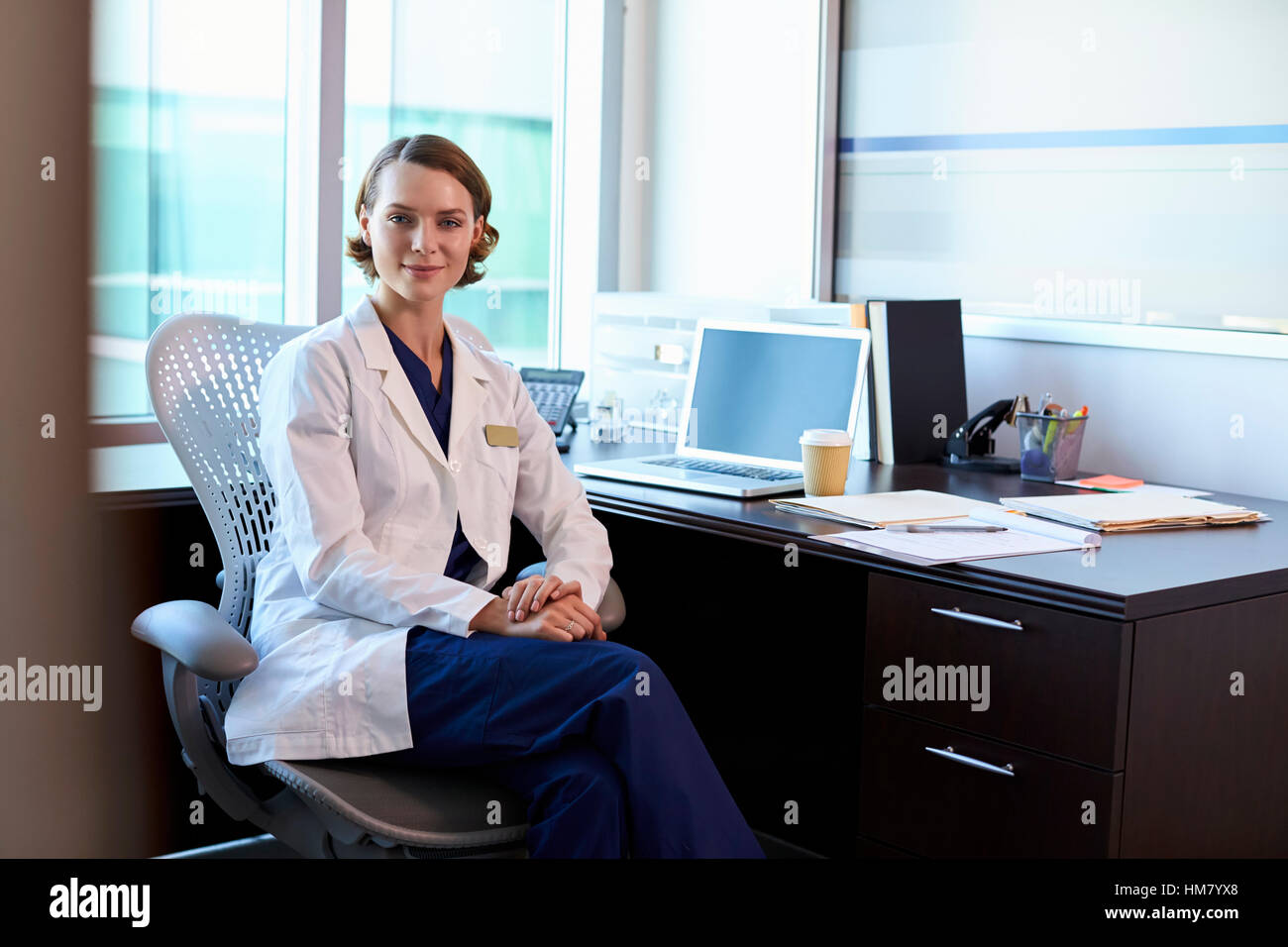 Portrait Of Female Doctor Wearing White Coat In Office Stock Photo