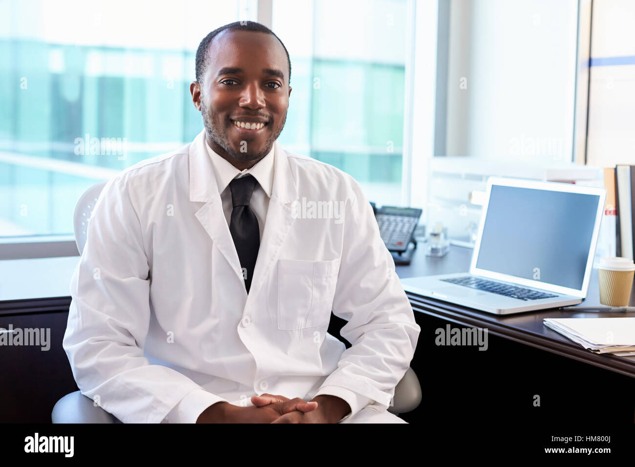 Portrait Of Doctor Wearing White Coat In Office Stock Photo