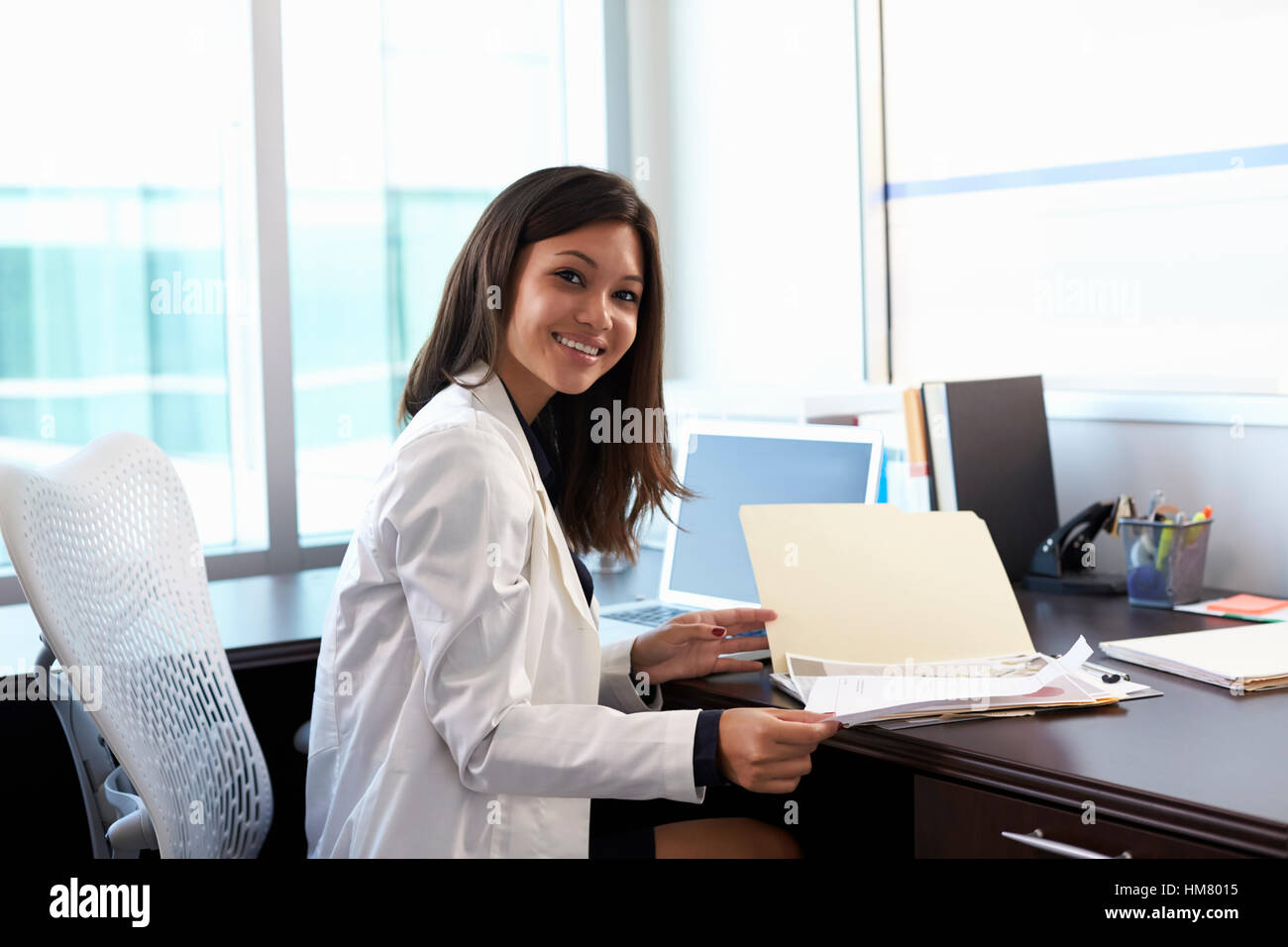 Portrait Of Female Doctor Wearing White Coat In Office Stock Photo