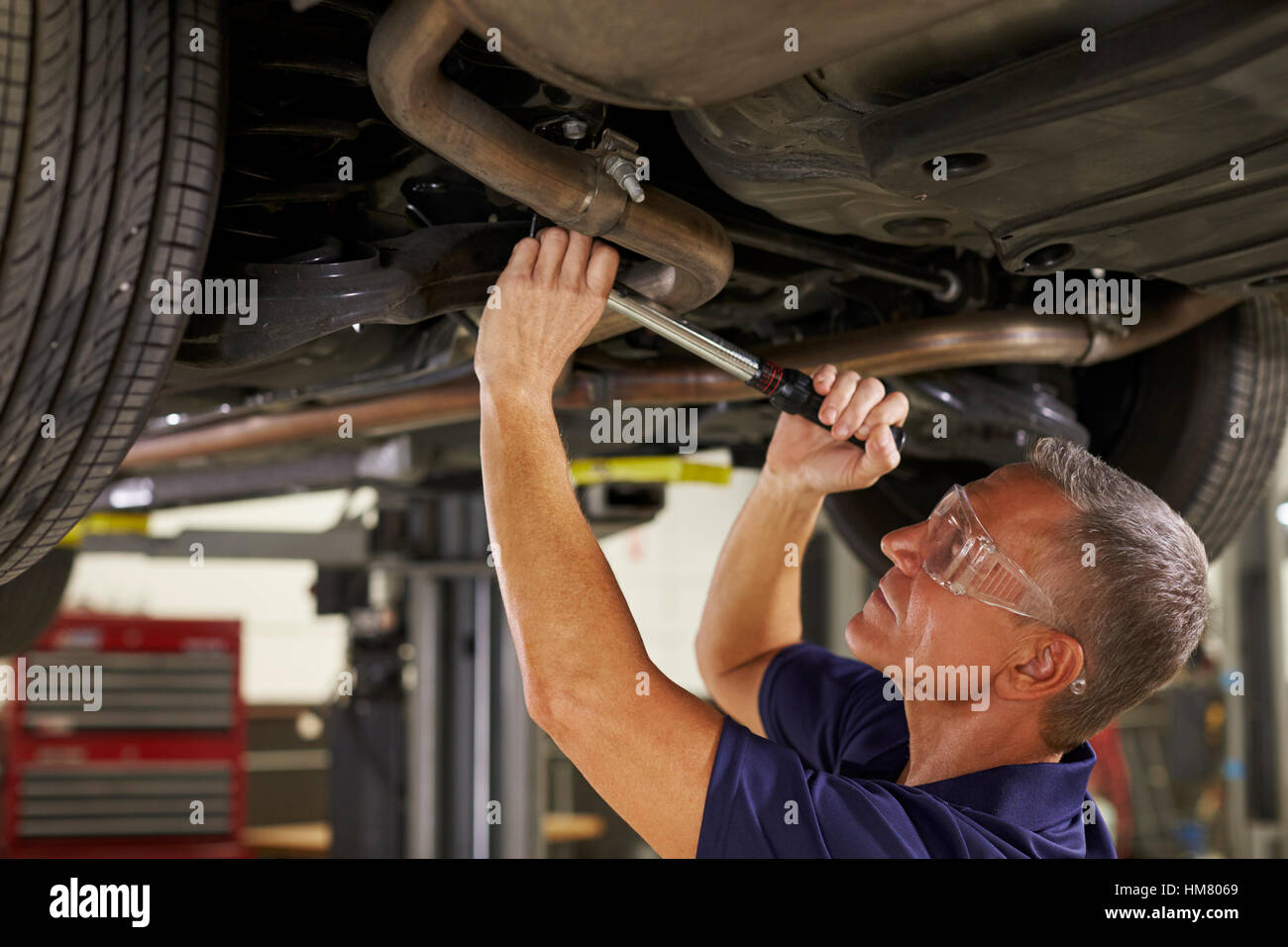 Auto Mechanic Working Underneath Car In Garage Stock Photo Alamy