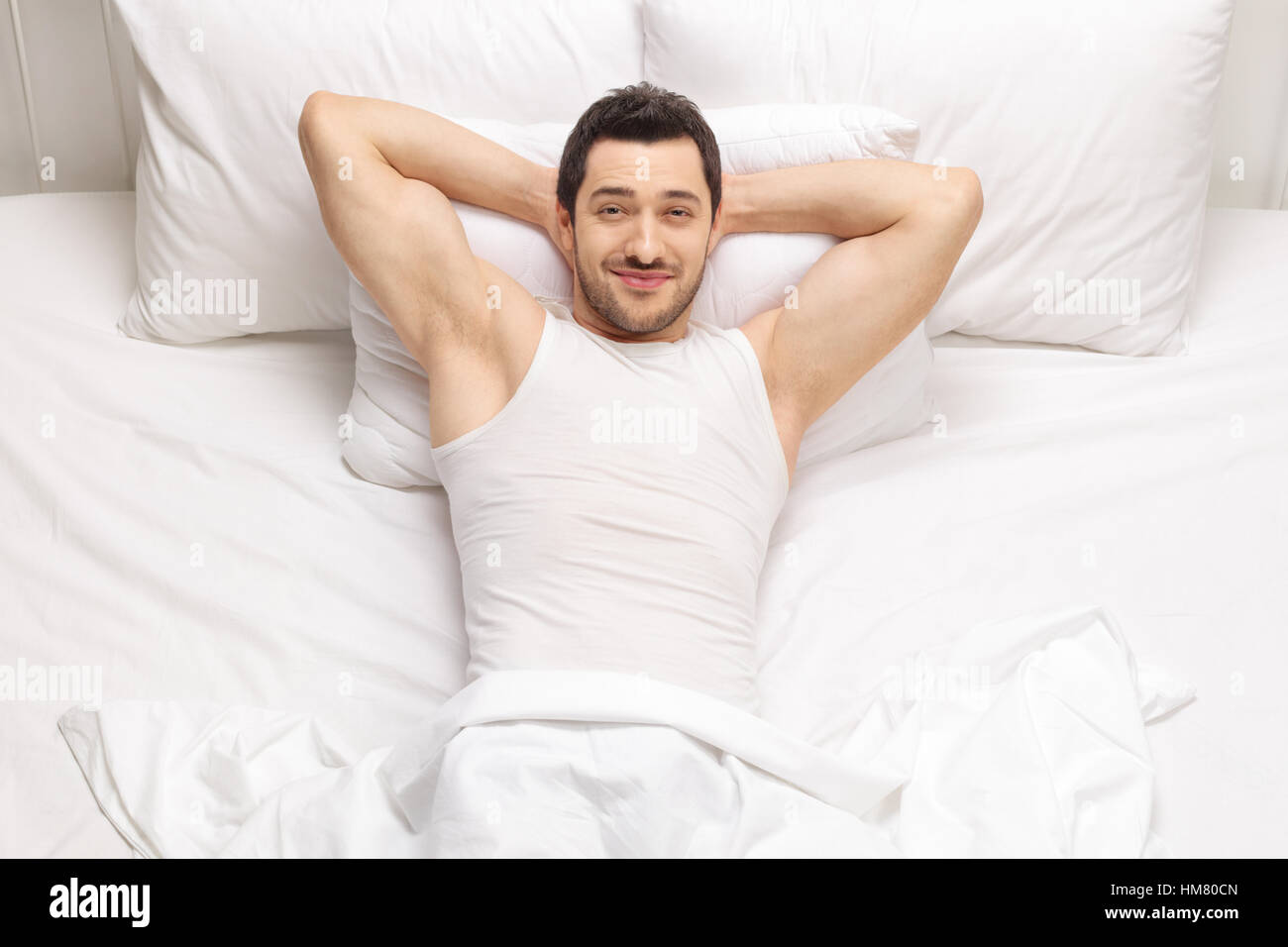 Handsome man lying in bed and looking at the camera Stock Photo