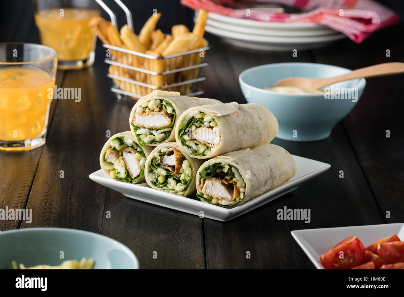Breaded Chicken burrito Wrap With Fresh Lettuce Cheese on rustic background Stock Photo
