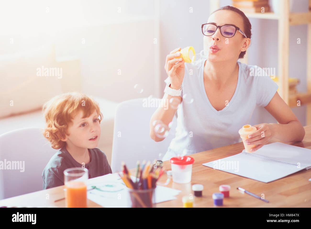 Happy mother and son blowing bubbles Stock Photo