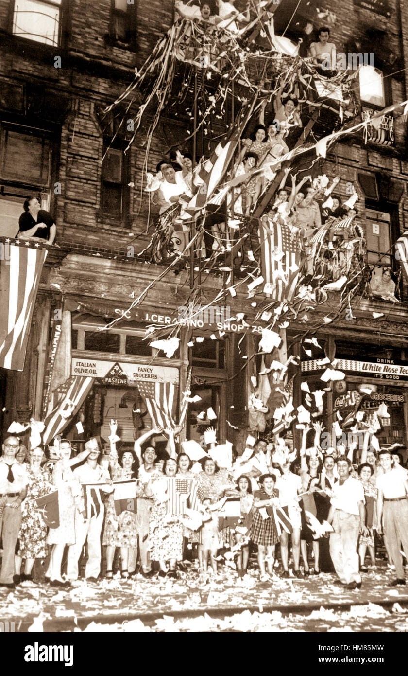 Americans of Italian descent in New York City wave flags and toss paper into the air as they celebrate the news of Japan's unconditional surrender to the Allies on August 14, 1945.  Press Association.  (OWI) NARA FILE #:  208-N-43468 WAR & CONFLICT BOOK #:  1360 Stock Photo