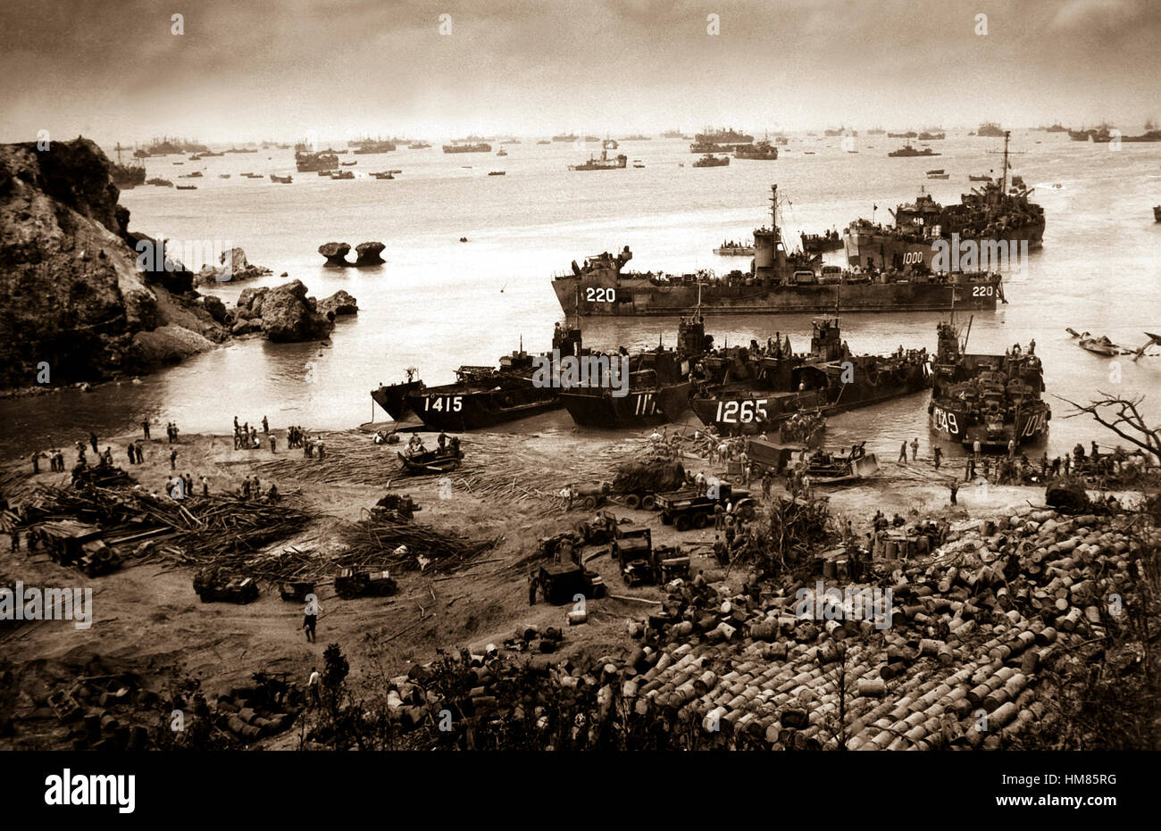 A formidable task force carves out a beachhead, about 350 miles from the Japanese mainland.  Landing craft of all kinds blacken the sea out to the horizon, where stand the battlewagons, cruisers and destroyers.  Okinawa, April 13, 1945.  (Coast Guard) NARA FILE #:  026-G-4426 WAR & CONFLICT BOOK #:  1226 Stock Photo