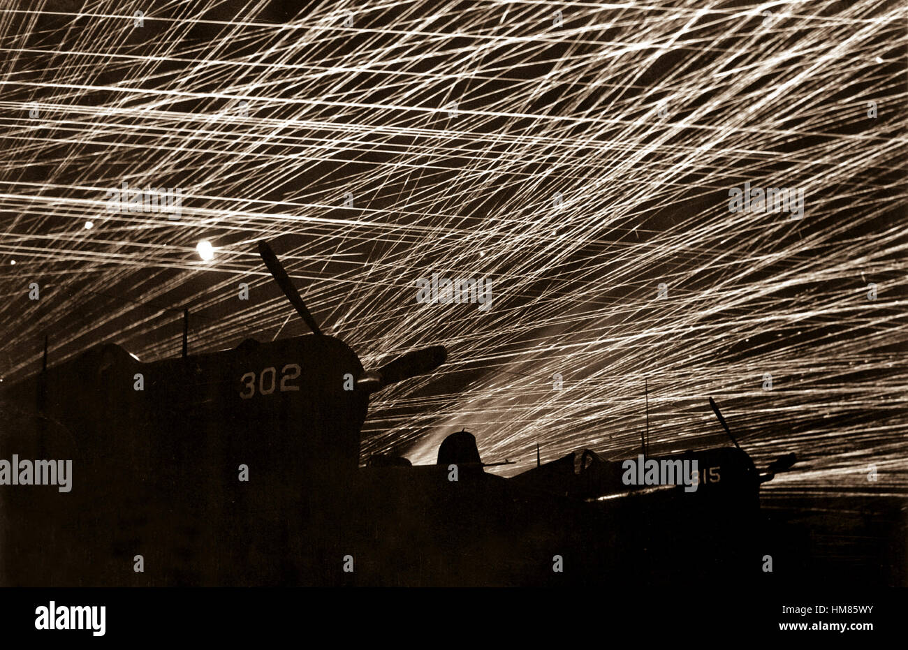 Japanese night raiders are greeted with a lacework of anti-aircraft fire by the Marine defenders of Yontan airfield, on Okinawa.  In the foreground are Marine Corsair fighter planes of the 'Hell's Belles' squadron.  1945.  T.Sgt. Chorlest.  (Marine Corps) Exact Date Shot Unknown NARA FILE #:  127-G-118775 WAR & CONFLICT BOOK #:  1235 Stock Photo