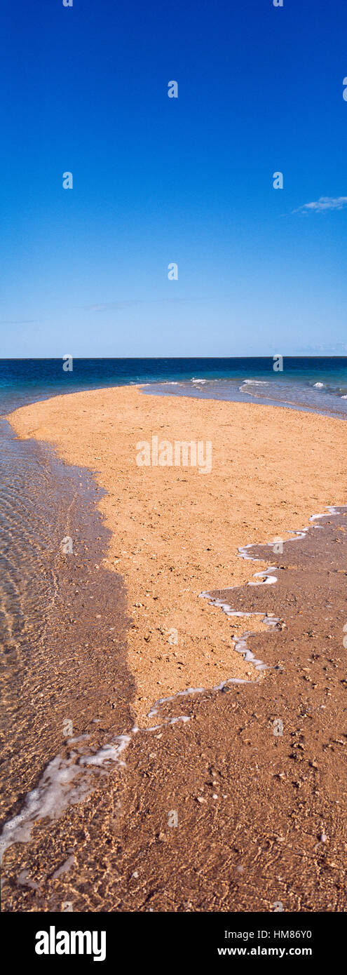 The rising tide swallows a small sand island. Stock Photo