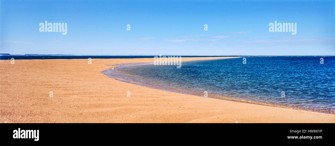 The rising tide swallows a small sand island. Stock Photo