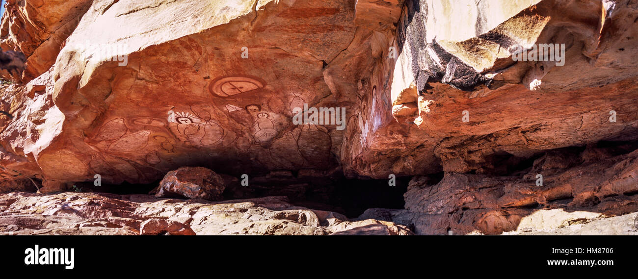 The rich ochre colours of an Aboriginal rock painting gallery featuring The Great Fish Chase. Stock Photo