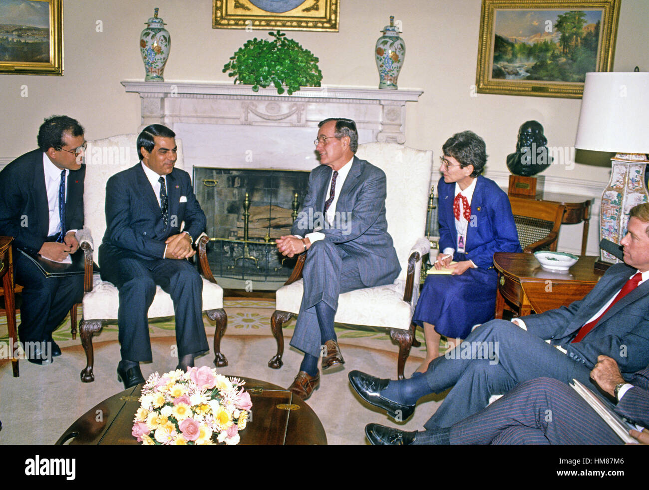 United States President George H.W. Bush, right, meets President Zine El Abidine Ben Ali of Tunisia in the Oval Office of the White House in Washington, D.C. on November 16, 1989. Vice President Dan Quayle looks on from the far right..Credit: Ron Sachs / Stock Photo