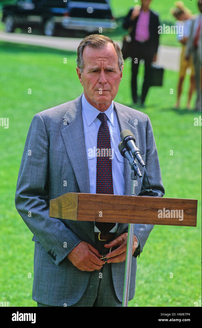 United States President George H.W. Bush speaks to reporters about the Iraqi invasion of Kuwait prior to leaving the White House for the presidential retreat at Camp David on August 3, 1990. Stock Photo