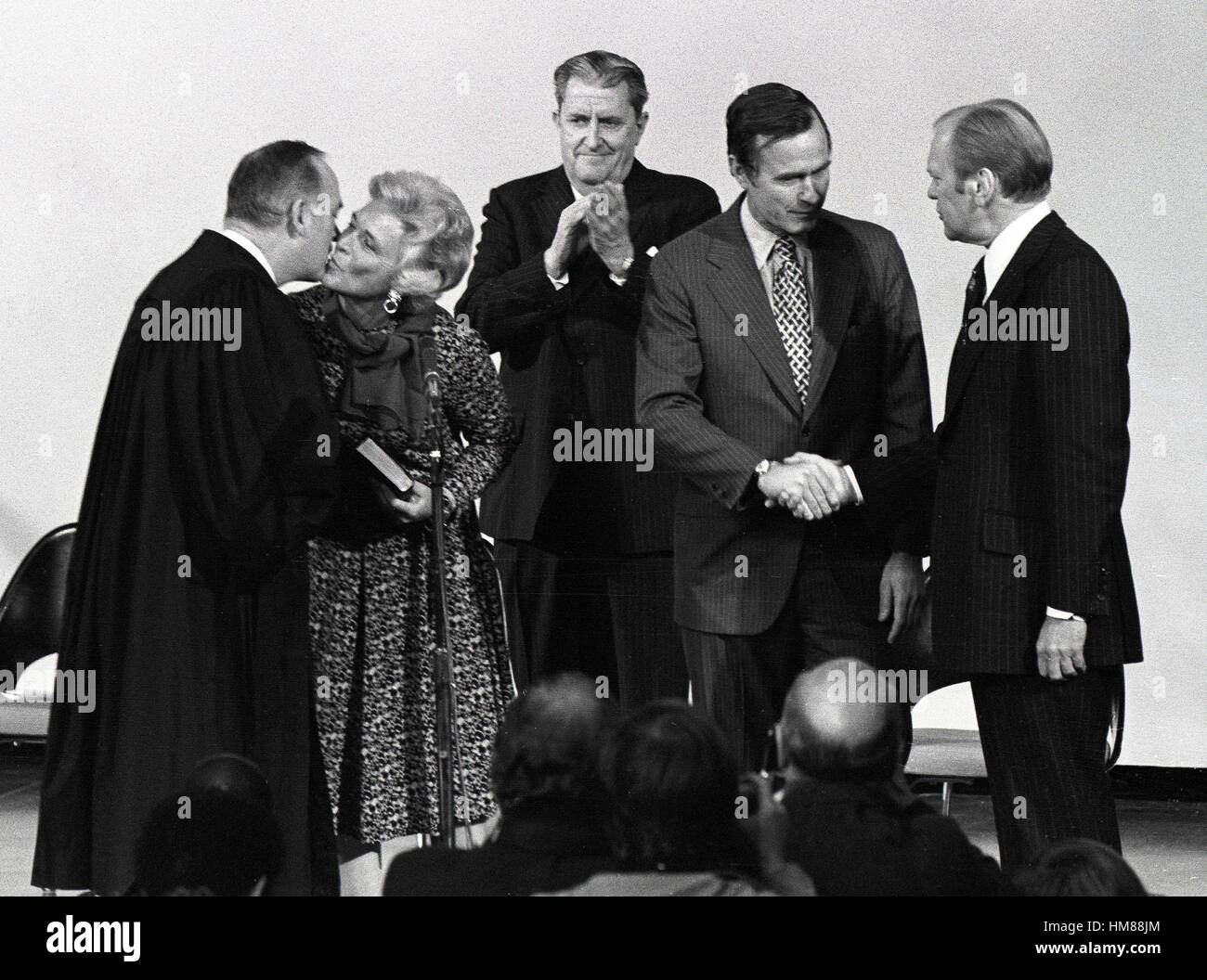 United States President Gerald R. Ford shakes hands with George H.W. Bush, who was sworn-in as Director of the Central Intelligence Agency (CIA) at the agency's headquarters in Langley, Virginia on January 30, 1976. From left to right: Associate Justice o Stock Photo