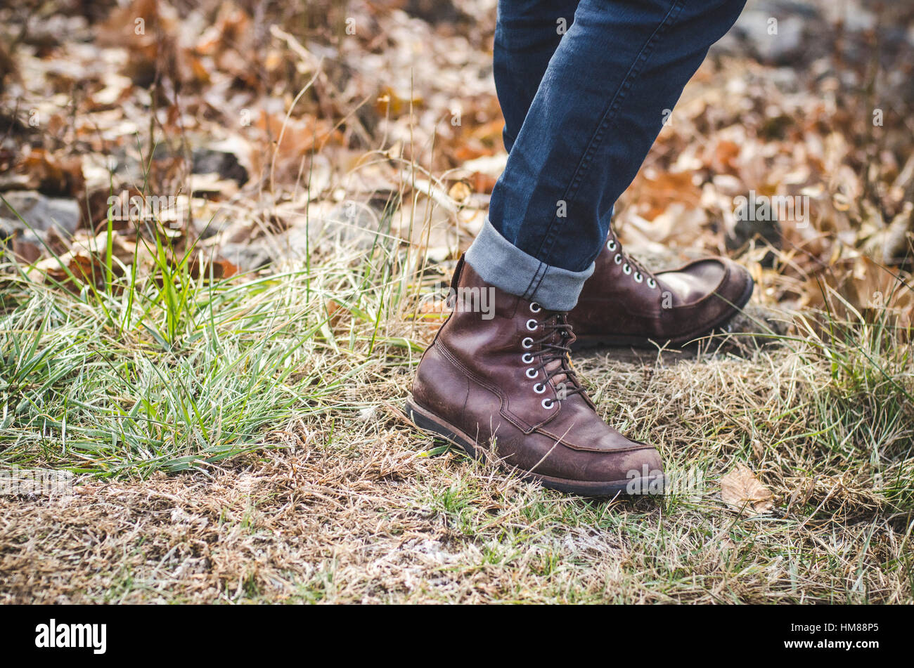 Man Wearing Cuffed Jeans and Boots on Grass Stock Photo - Alamy