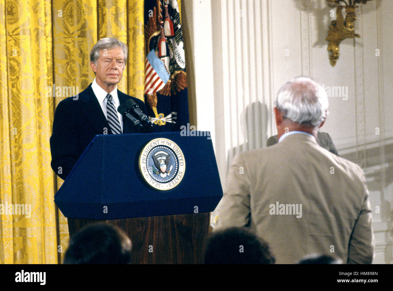 United States President Jimmy Carter listens to a reporter's question as he holds a press conference in the East Room of the White House in Washington, DC on August 4, 1980. The President discussed the scandal surrounding his brother Billy. Carter said th Stock Photo