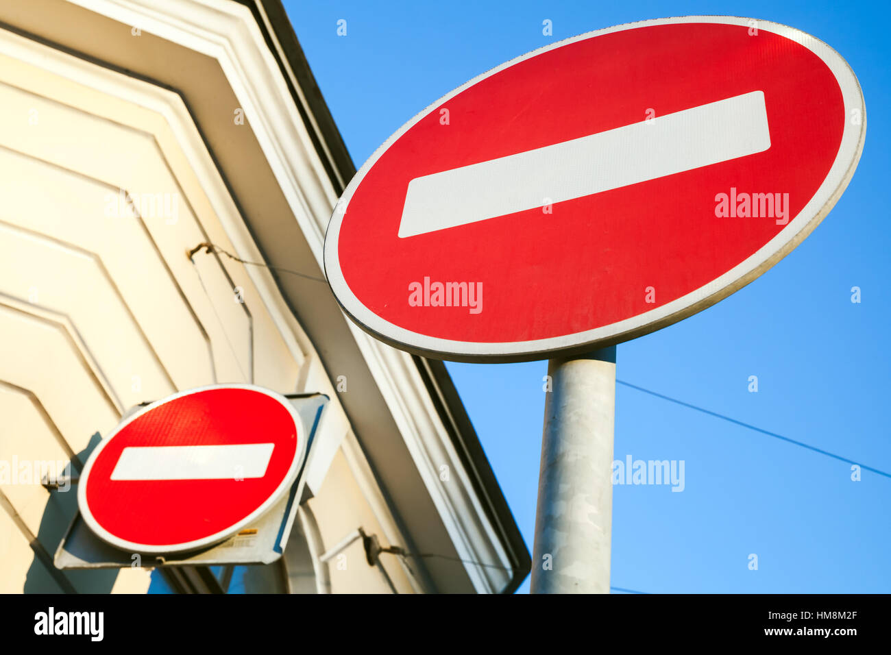 Two round red signs No Entry near old house Stock Photo