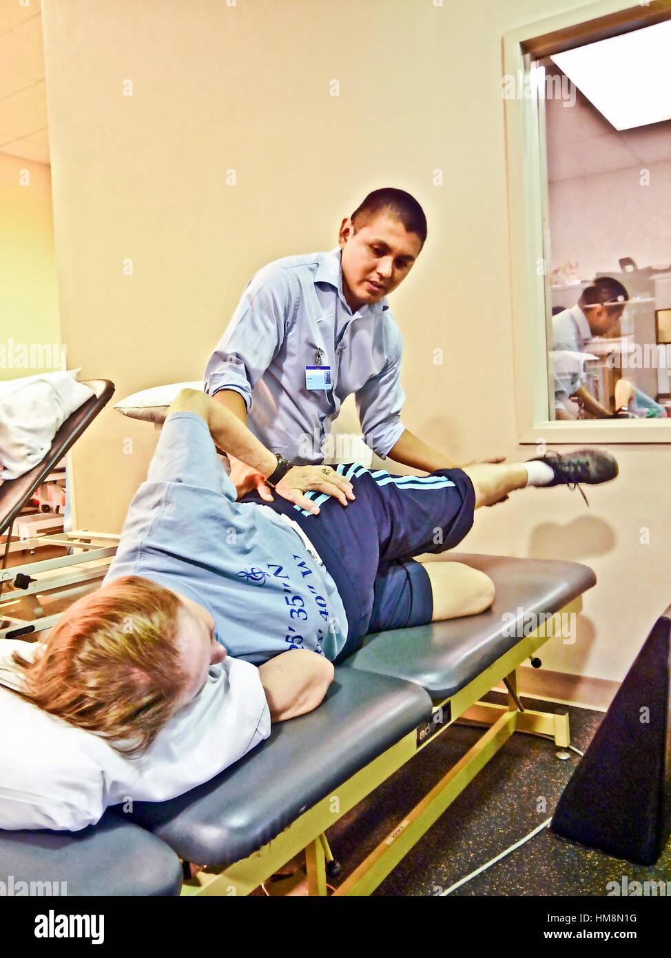 A physical therapist works on a patient following knee replacement