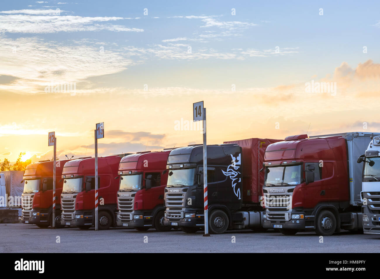 Narva, Estonia - August 20, 2016: Scania Heavy trucks loaded with goods trailers, parked in waiting area on Estonian-Russian state border crossing. In Stock Photo