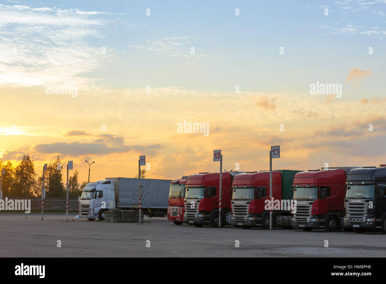 Narva, Estonia - August 20, 2016: Scania, Renault & Volvo heavy trucks loaded with goods trailers, parked in waiting area on Estonian-Russian state bo Stock Photo