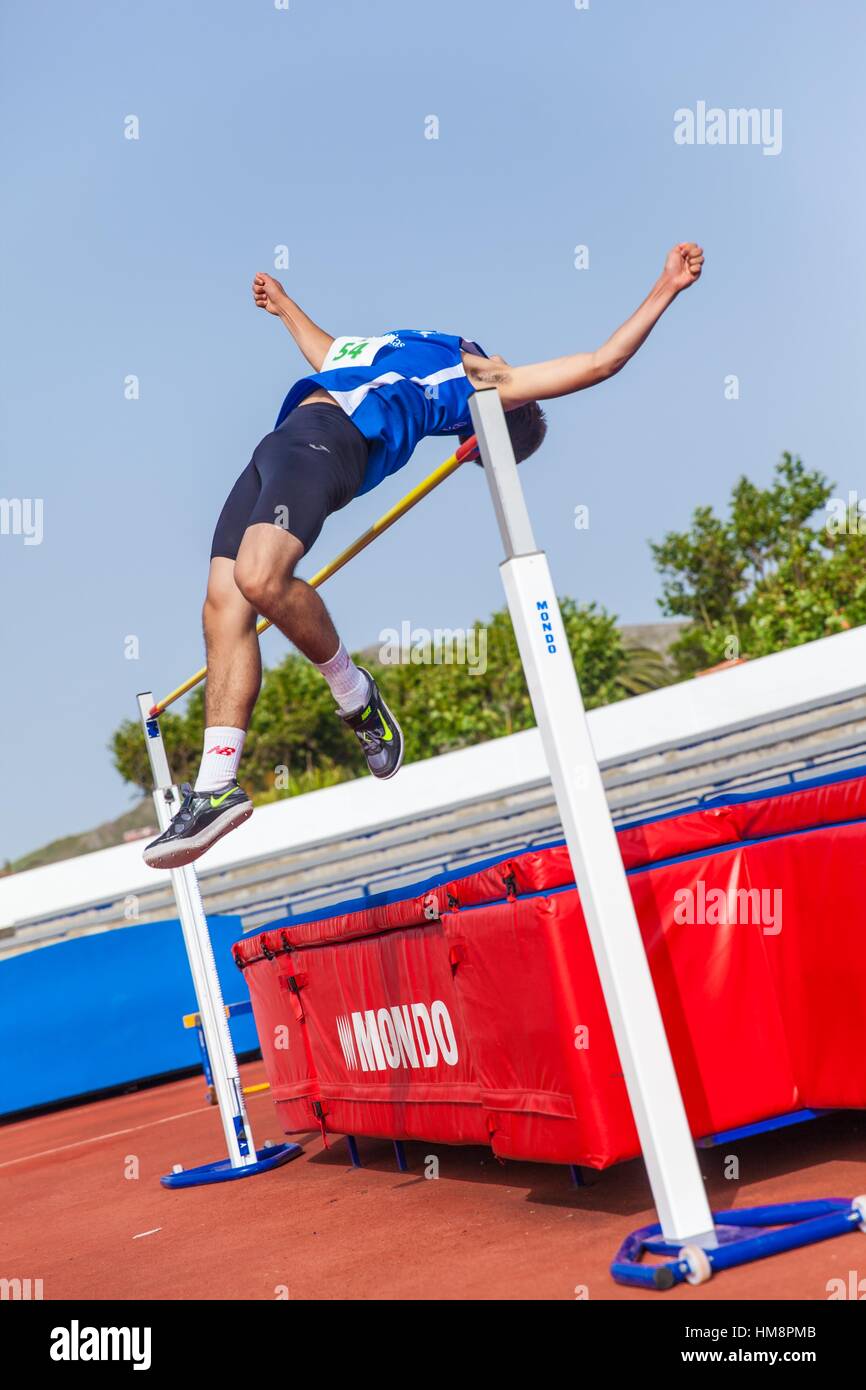 Sports boy performing the high jump on an athletic piste Stock Photo
