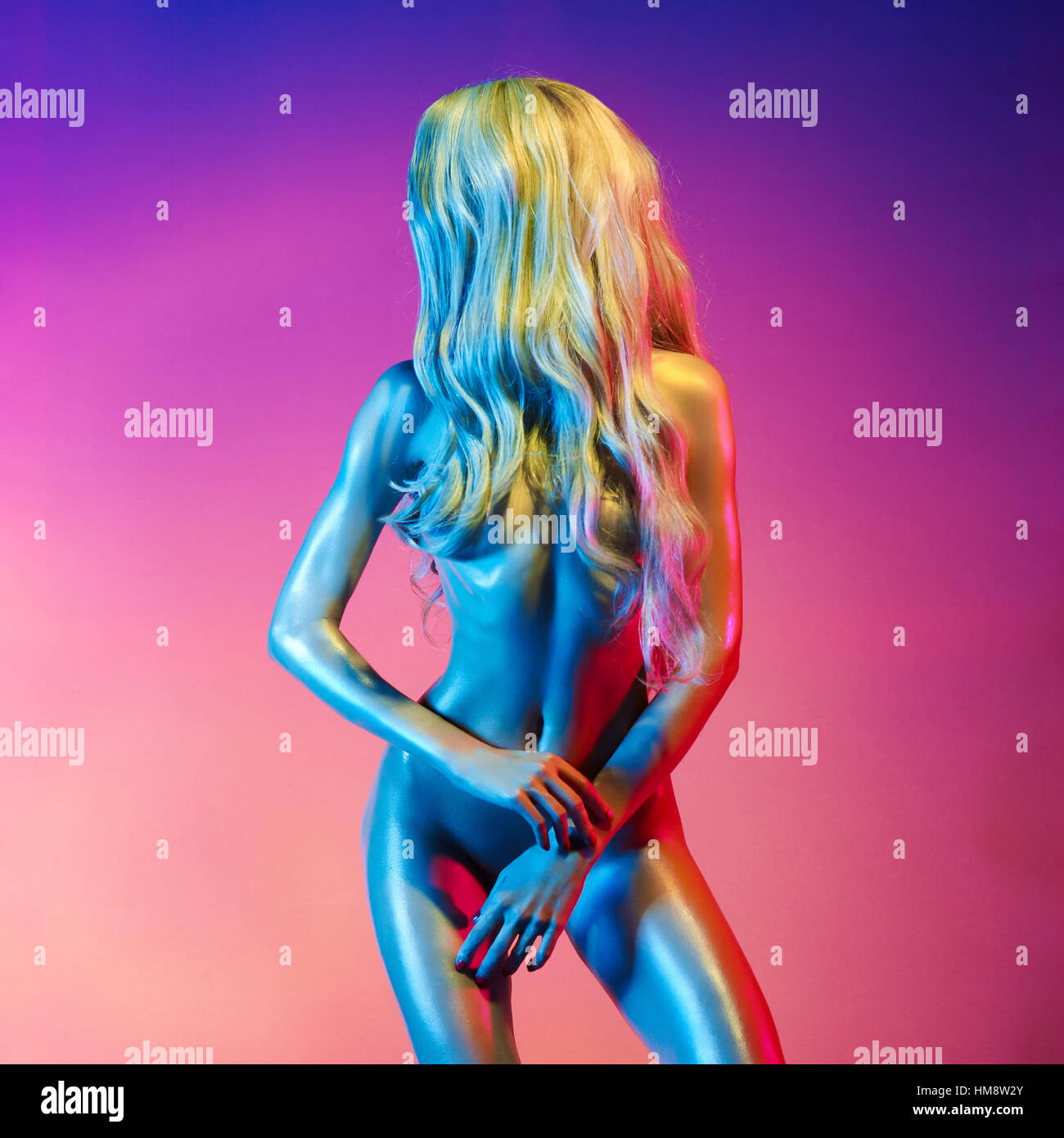 Nude beautiful blonde dancing in colorful light. Erotic portrait of sexy  woman with long hairs Stock Photo - Alamy