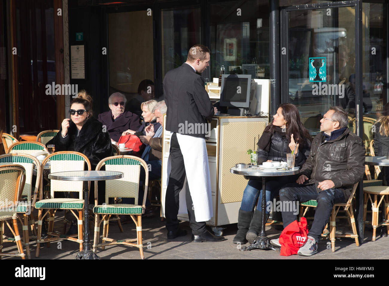 Tourists sitting outside cafe in Paris in winter Stock Photo