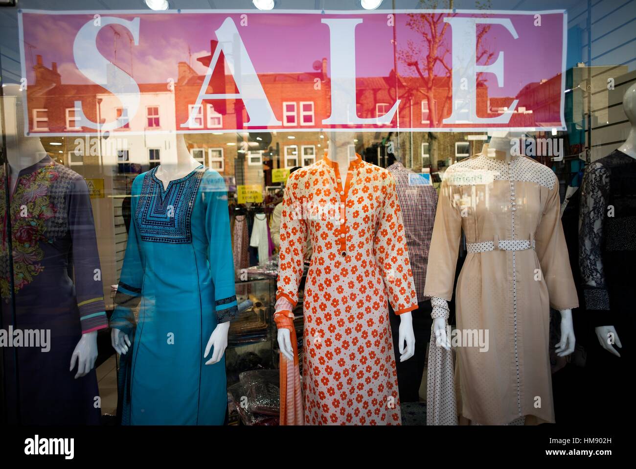 Shop window of trendy indian cloths with a sign of SALE and reflections
