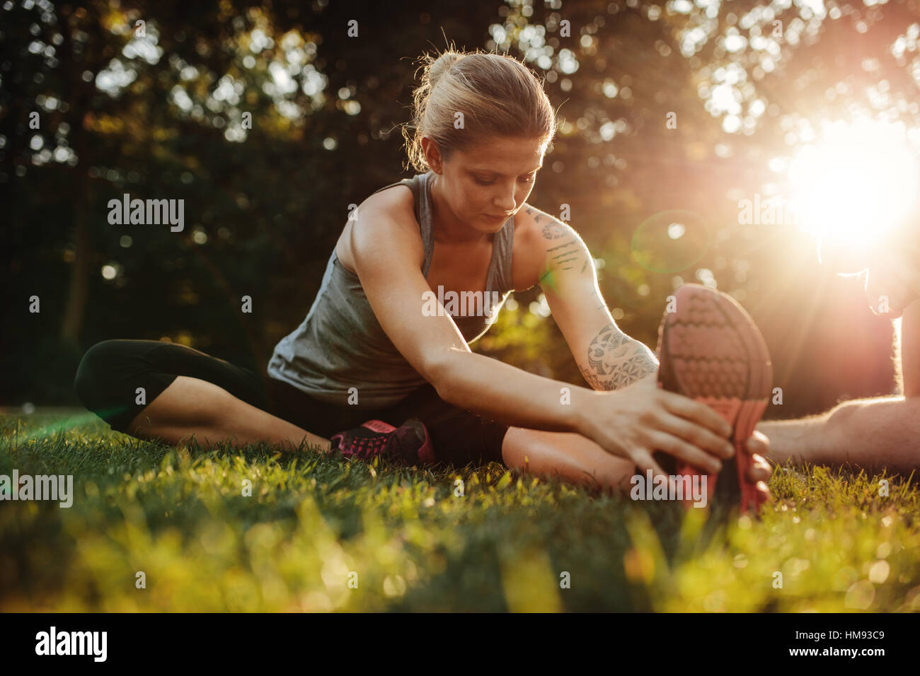 Healthy young woman exercising at park. Fit young woman doing training workout in morning. Stock Photo