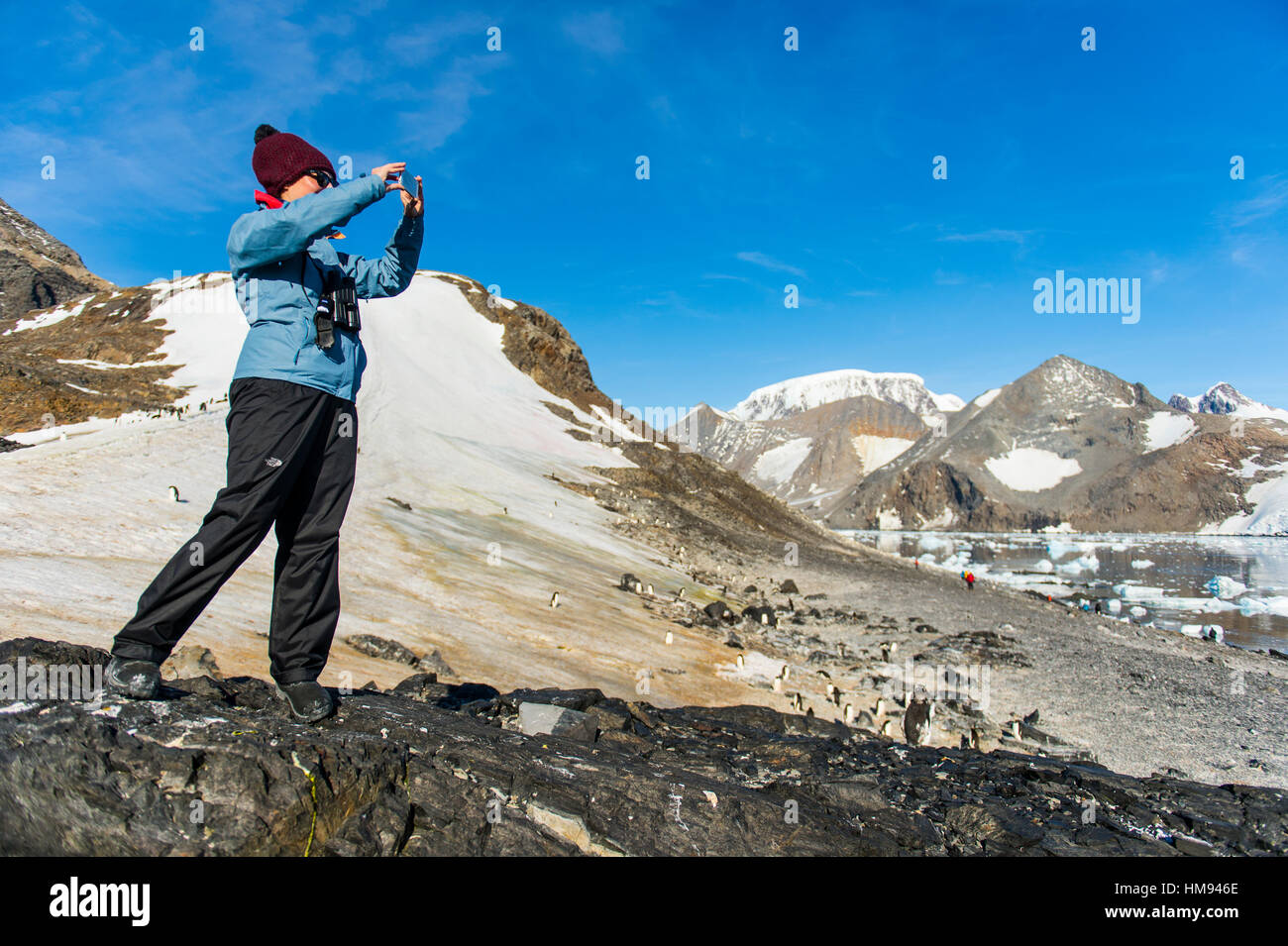 Tourist photographing the beautiful bay filled with icebergs in Hope Bay, Antarctica, Polar Regions Stock Photo