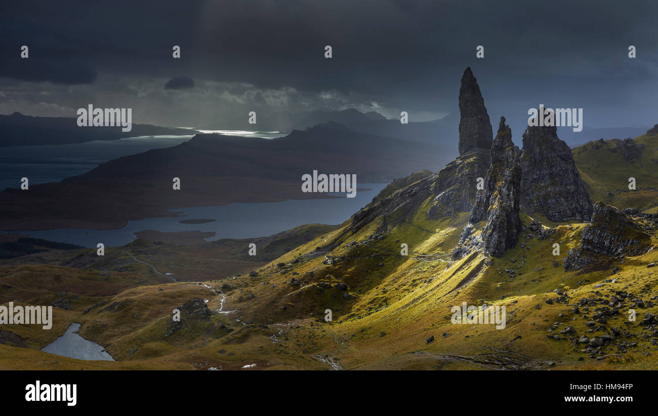 A burst of light briefly illuminates the pinnacles surrounding the Old Man of Storr, Isle of Skye, Scotland, UK Stock Photo