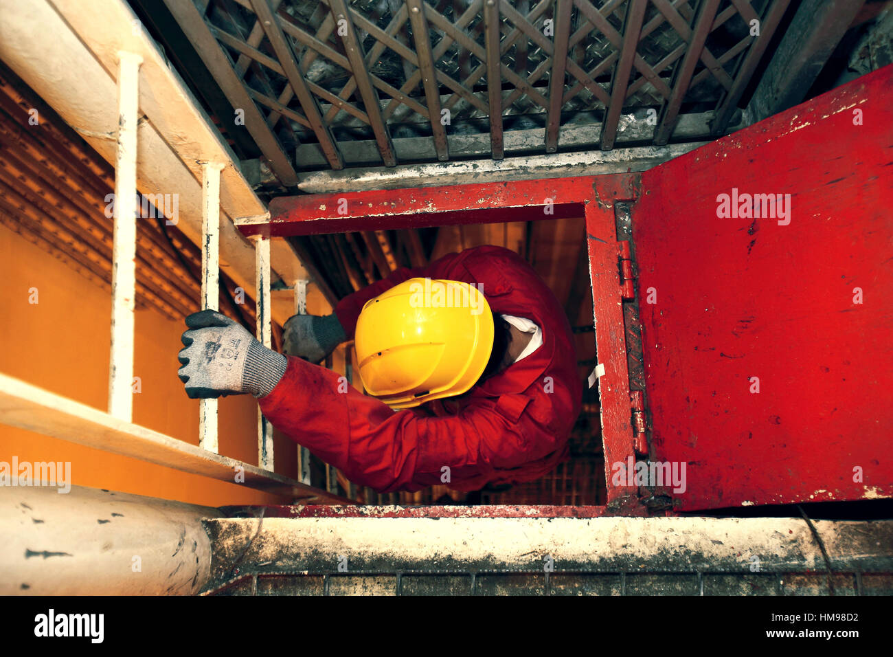 Workman climbing down a ladder Stock Photo Alamy