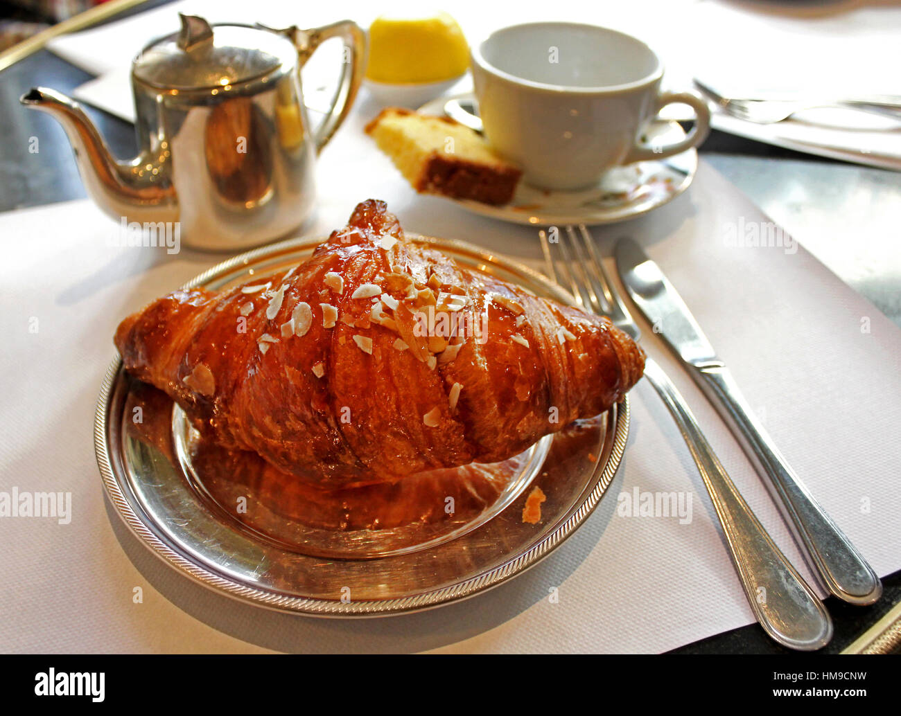 Croissant with tea on the table in a café Stock Photo