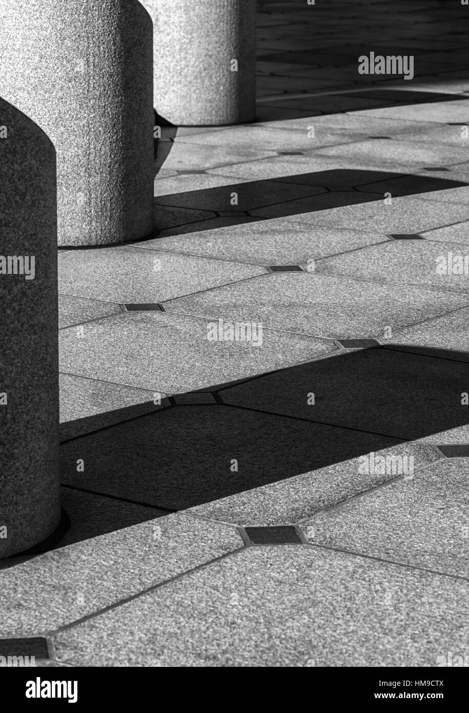 concrete columns casting shadows on the ground; urban geometry. Stock Photo