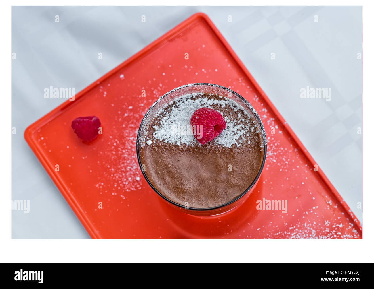 Homemade chocolate mousse with fresh raspberries on an orange serving ...