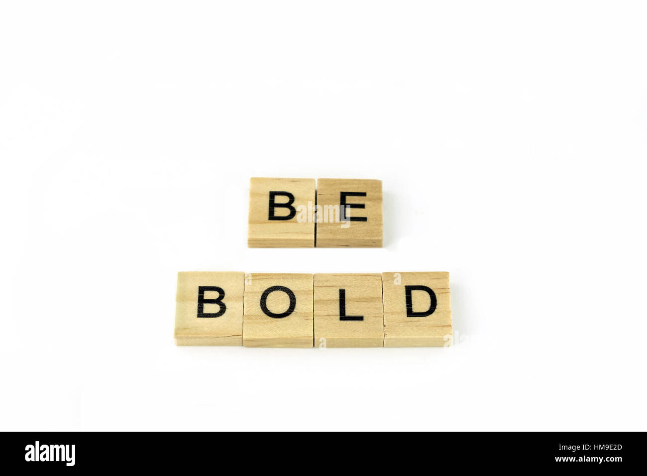 Wooden blocks spelling out Be Bold on a white background. Cutout. Concept, conceptual. Stock Photo