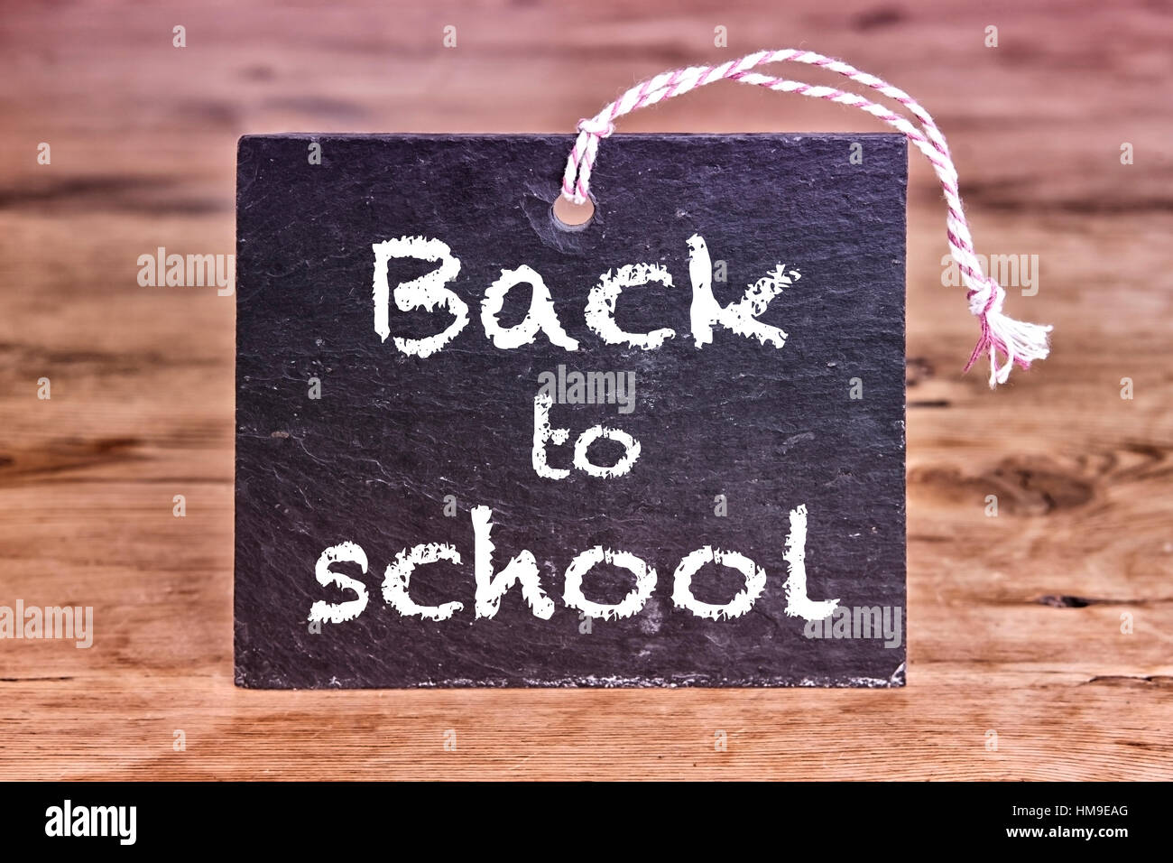 the words Back To School written on chalkboard on wooden table Stock Photo