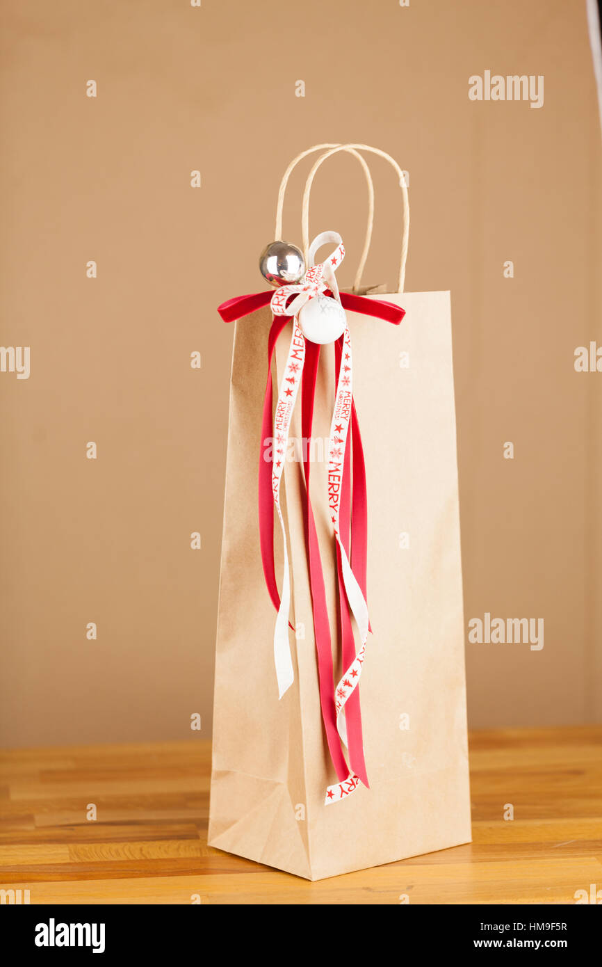 Close Up Of Christmas Gift Bag Of Kraft Paper With Red And White
